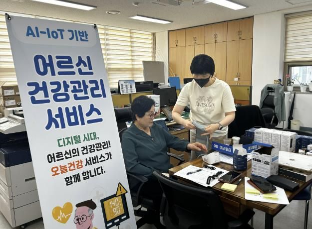 보성군, AI-IoT 기반 어르신 건강 관리 사업 본격 추진_AI-IoT 사업 전문인력이 대상자에게 혈압측정 하는 방법을 알려주고 있다
