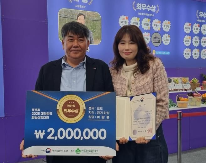 27일 열린 제15회 2025 대한민국 과일산업대전에서 포도분야 최우수상으로 선정된 이완용 송산포도팜스토리 대표가 기념촬영을 하고 있다