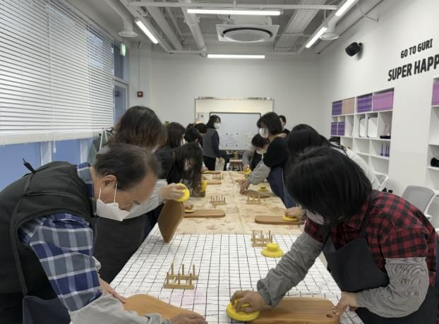 전통시장 제2공영주차장빌딩 1층 홍보관에서 열린 원데이클래스 현장. 참가자들이 목공 도구를 활용해 나무도마를 제작하며 수공예 체험을 즐기고 있다. /사진제공=구리시상권활성화재단