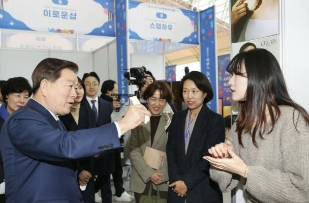 박승원 광명시장(사진 왼쪽)이 2024년 광명스피돔에서 열린 '2024 광명시 스타트업 페스티벌'의 전시·체험 부스에 참여한 기업 제품을 체험해 보고 있다.