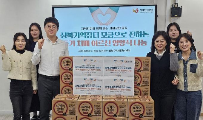 성북구치매안심센터 관계자들이 취약계층 치매 독거 어르신 지원 물품 전달식 후 기념촬영을 하고 있다